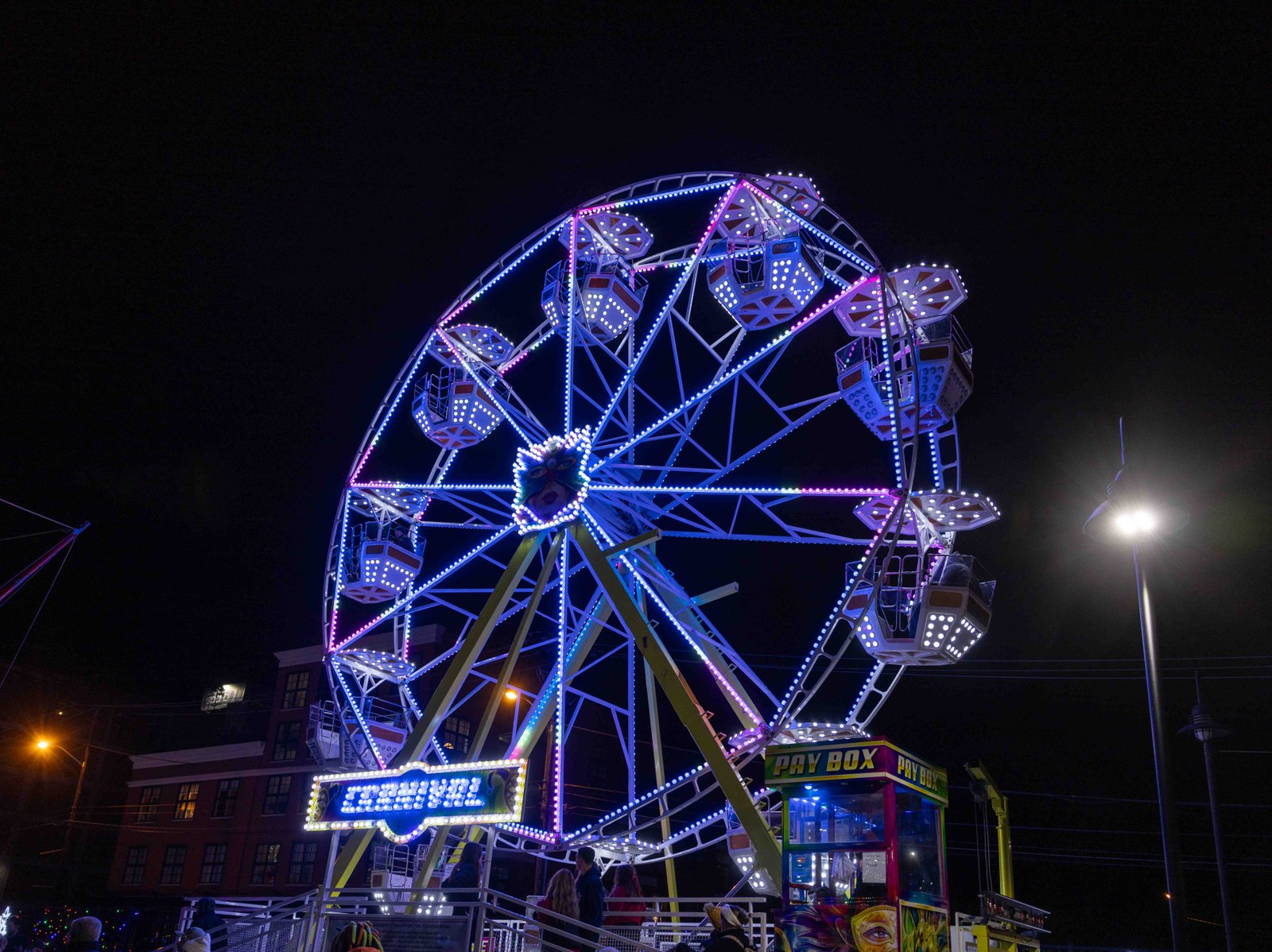 Charleston's Light the Night festivities Ferris wheel lit up in neon blue at Charleston's festive event captured by UA-Visions.